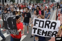 Demonstrators march with a sign that says in Portuguese "Get out Temer" and a drawing of Cuba's late President Fidel Castro, as they demand the impeachment of Brazil's President Michel Temer in Sao Paulo, Nov. 27, 2016.