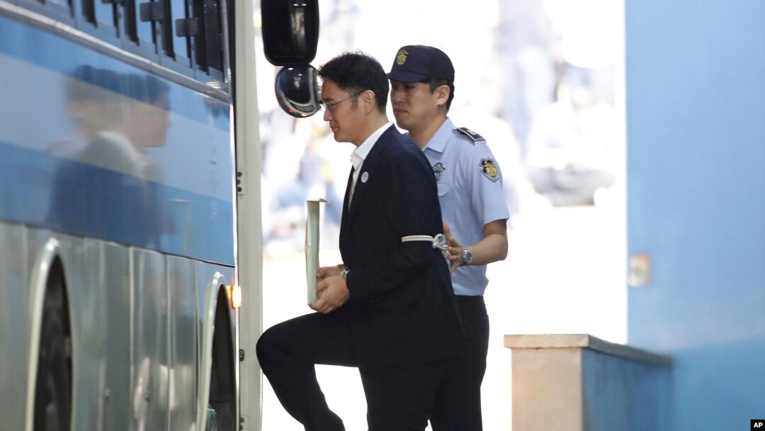 Phó Chủ tịch Lee Jae-Young (trái) của tập đoàn Samsung chuẩn bị bước lên xe sau khi rời tòa đã tuyên án ông 5 năm tù hôm 25/8/2017.