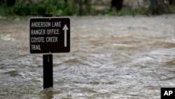 A sign is submerged in the water from Coyote Creek, Feb. 21, 2017, in Morgan Hill, Calif. Rains have saturated once-drought stricken California but have created chaos for residents hit hard by the storms. 