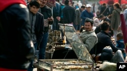 FILE - Uighur jade vendors sell their wares at an outdoor curio market where Chinese police have been checking their IDs everyday since a vehicle attack in Beijing, China.