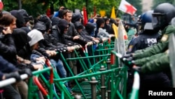 Cảnh sát chống bạo loạn cố ngăn người biểu tình, phản đối cách xử lý cuộc khủng hoảng nợ, vượt qua hàng rào gần trụ sở Ngân hàng Trung ương Âu châu, ở Frankfurt 21/5/13