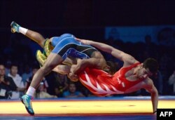 ordan Burroughs of the United States takes down Ezzatollah Akbari Zarinkolaei of Iran during the 2014 FILA Freestyle Wrestling World Cup on March 15, 2014 in Inglewood, California.