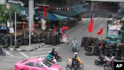 Traffic passes a barricade in Bangkok, Thailand, 13 May 2010