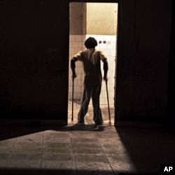 A November 2011 file photo shows a youth suffering from polio walking through a doorway at the Stand Proud compound in Kinshasa, Republic of Congo