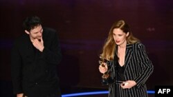 French director and screenwriter Justine Triet (R) and French director and screenwriter Arthur Harari accept the award for Best Original Screenplay for "Anatomy of a Fall" onstage during the 96th Annual Academy Awards at the Dolby Theatre in Hollywood, Ca