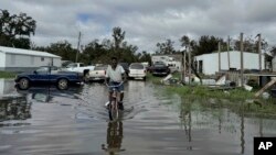 Carter Caldwell, 69, bikes through his family's flooded property just south of Houma, Louisiana after Hurricane Francine passed through the area, Sept. 12, 2024. 