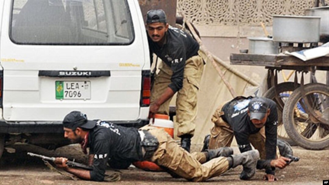 Pakistani police commandos take position outside one of the two stormed mosques by gunmen in Lahore, 28 May 2010