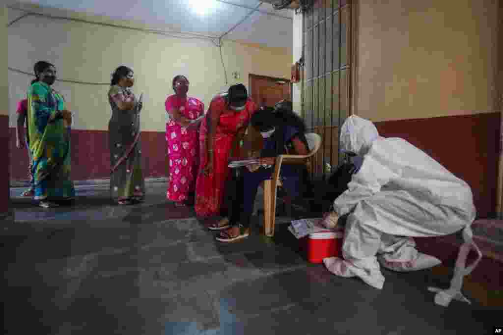 اهالی یکی از بزرگترین محله‌های فقیرنشین آسیا، در بمبئی هند، در صف ثبت‌نام برای تست کووید – ۱۹ ایستاده‌اند.