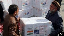 FILE- Afghan health ministry workers unloads boxes of the first shipment of 500K doses of the AstraZeneca coronavirus vaccine made by Serum Institute of India, donated by the Indian government in Afghanistan, Feb. 7, 2021. India has delivered two tons of medicines to Afghanistan.