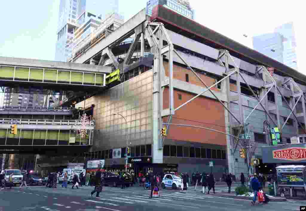 People walk past Port Authority Bus Terminal as police respond to a report of an explosion near Times Square on Dec. 11, 2017, in New York.