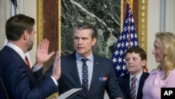 ARCHIVO - El vicepresidente JD Vance, de izq a der, toma juramento a Pete Hegseth como secretario de Defensa mientras su esposa Jennifer Rauchet sostiene la Biblia y el hijo de Hegseth observa en la Casa Blanca en Washington, el 25 de enero de 2025.