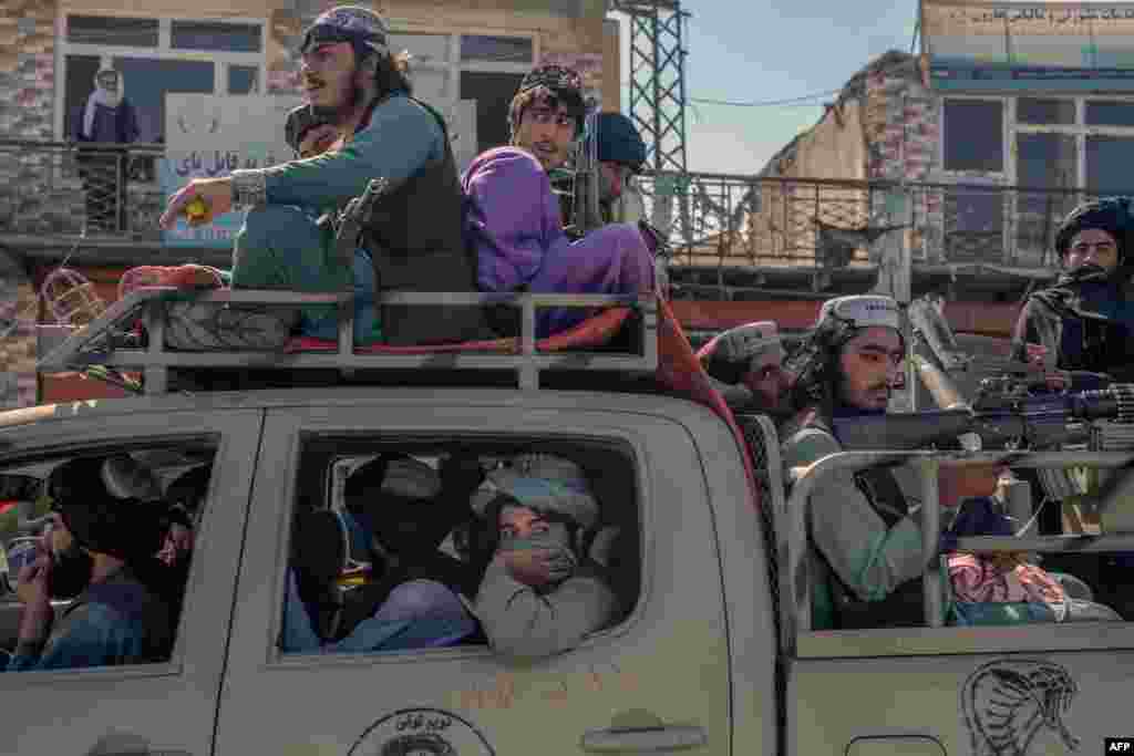 Taliban militants drive along a road in the center of Kabul, Afghanistan.