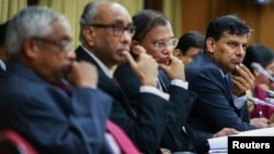 FILE - The Reserve Bank of India (RBI) Governor Raghuram Rajan and other officials listen to a question during a news conference after the bi-monthly monetary policy review in Mumbai, Dec. 2, 2014. 