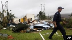 A policeman walks past the remains of a house that was destroyed by Cyclone Yasi in the northern Australian town of Tully, February 3, 2011.