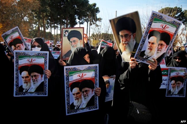 Pro-government demonstrators hold posters of Iran's supreme leader, Ayatollah Ali Khamenei (L) and Iran's founder of Islamic Republic, Ayatollah Ruhollah Khomeini during a march in Iran's holy city of Qom.