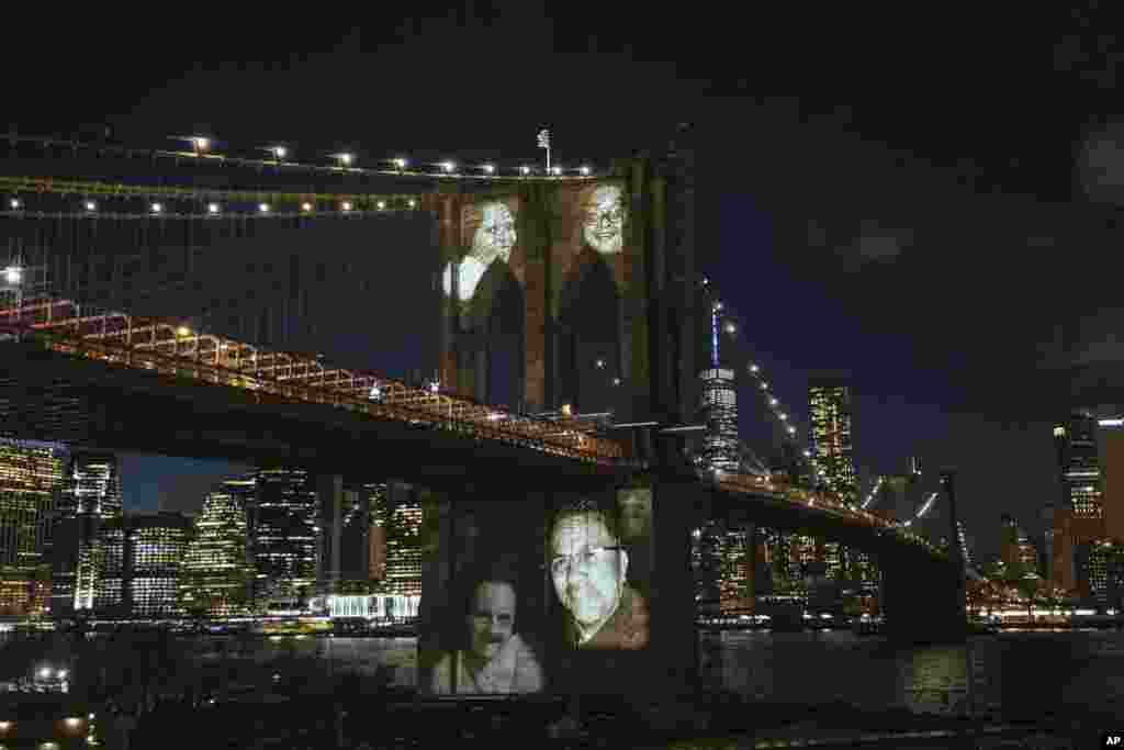 New Yorkers who died during the coronavirus pandemic are projected onto the Brooklyn Bridge during a commemoration ceremony, March 14, 2021, in Brooklyn, New York.