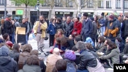 A speaker addresses a crowd on the Place de la Republique, in Paris, France, (L. Bryant/VOA). The gathering is part of "Nuit Debout," - a movement which one observer calls "a bit complex to define."