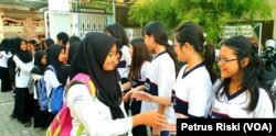 Siswa-siswi SD Kristen Petra Jombang menyalami siswa-siswi Madrasah Ibtidaiyah (MI) Islamiyyah-Plosogenuk yang mengunjungi sekolah mereka (Foto:VOA/Petrus Riski).