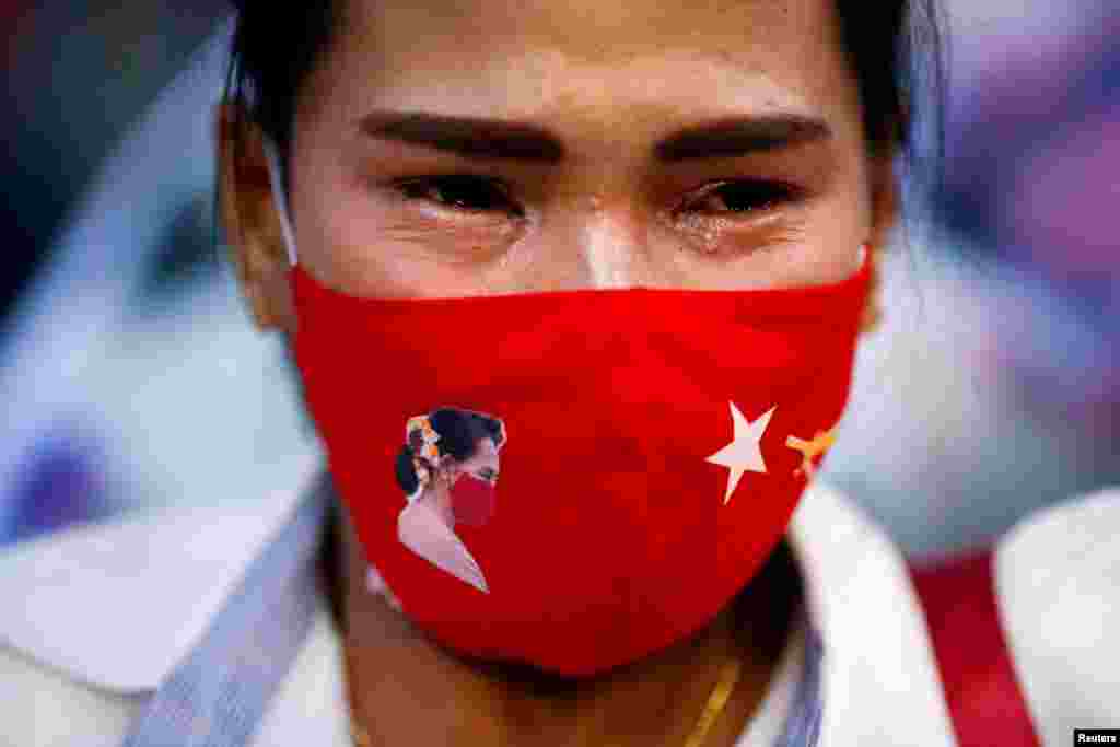 A woman cries during a prayer ceremony for those who died in Myanmar during anti-coup protests, in front of the U.N. building in Bangkok, Thailand.