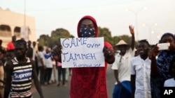 Manifestante exibe, em Serrekunda, Gâmbia, um cartaz com os dizeres "Fim da picada, Jammeh"