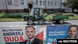 FILE - Election posters of incumbent Polish President Andrzej Duda, left, and Warsaw mayor and presidential candidate of the main Polish opposition party Civic Platform (PO) Rafal Trzaskowski hang on a fence in Leszno, Poland, July 6, 2020.