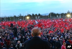 FILE - Turkey's President Recep Tayyip Erdogan delivers a speech during a rally a day after the referendum, outside the Presidential Palace, in Ankara, Turkey, April 17, 2017.