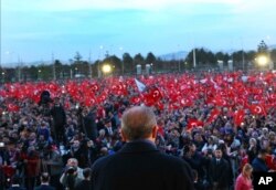 FILE - Turkey's President Recep Tayyip Erdogan delivers a speech during a rally a day after the referendum, outside the Presidential Palace, in Ankara, Turkey, April 17, 2017.