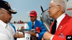 FILE - Tuskegee Airmen Detroit Chapter President Arthur Green, left, holds a P-51 D model plane as Lt. Col. Harry Stewart, Jr., center, and Col. Charles McGee, right sign their autographs June 19, 2012, at Selfridge Air National Guard Base. 