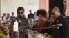La chanteuse Tshiala Muana (au centre), avec Koffi Olomide (à dr.) et Werrason (à g.) lors d'une cérémonie en l'honneur de feu le musicien Tabu Ley Rochereau, au Palais du peuple à Kinshasa, le 9 décembre 2013. 