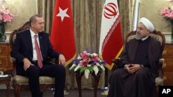 In this photo released by the official website of the office of the Iranian Presidency, Iran's President Hassan Rouhani, right, talks with his Turkish counterpart Recep Tayyip Erdogan at the Saadabad palace in Tehran, April 7, 2015.
