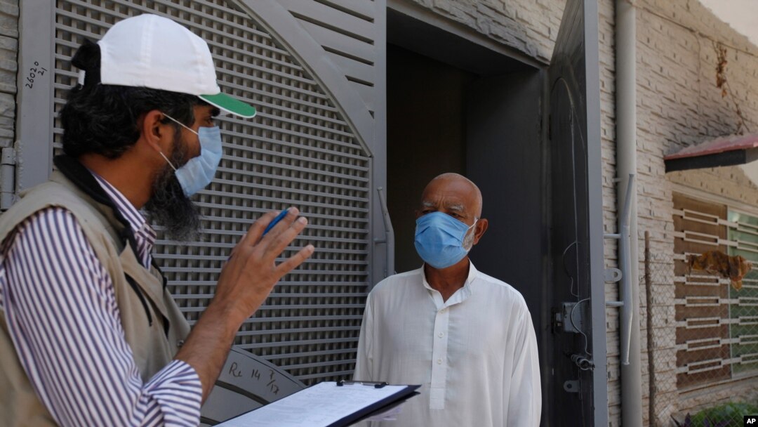 Seorang petugas kesehatan mencatat riwayat medis dari seorang warga sebelum mengambil sampel untuk tes Covid-19 yang dilakukan dari pintu ke pintu di Islamabad, Pakistan, 15 Juni 2020. 