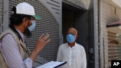 A health worker gets medical history from a person before taking sample during door-to-door testing and screening facility for the new coronavirus, in Islamabad, Pakistan, June 15, 2020. 