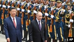 د کال ۲۰۲۴ د می د ۱۶ نېټې په دې تصویر کې د روس صدر ولادېمير پوټن دچین صدر شي جېن پينګ ترڅنګ بيجېنګ ته د رسېدو وروسته د هغه د هرکلي دپاره د چین د پوځي پریډ معاینه کوي 