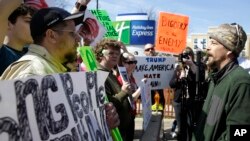 Donald Trump protesters argue with a supporter outside the Holiday Inn Express prior to a scheduled appearance by the Republican presidential candidate in Janesville, Wisconsin, March 29, 2016.