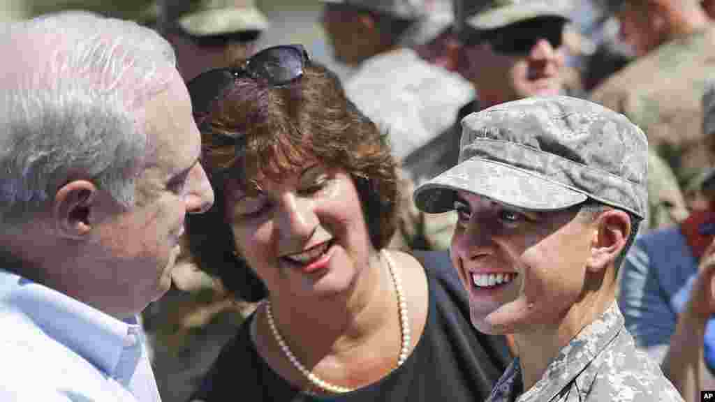 La première lieutenant Shaye Haver de l&rsquo;armée américaine, à droite, sourit après avoir reçu le précieux petit bout d&#39;étoffe noir et or, d&#39;un homme non identifié au cours d&rsquo;une cérémonie de remise des diplômes vendredi 21 août 2015, à Fort Benning, en Géorgie.