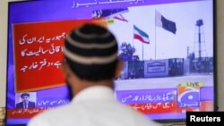 Seorang pria terlihat di layar televisi, setelah Kementerian Luar Negeri Pakistan mengatakan negaranya melakukan serangan yang menargetkan militan separatis di Iran, di Karachi. (Foto: Reuters)