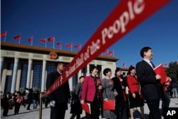 A soldier in usher uniform stands guard as delegates leave the Great Hall of the People after the closing session of China's National People's Congress (NPC) in Beijing, March 15, 2019.