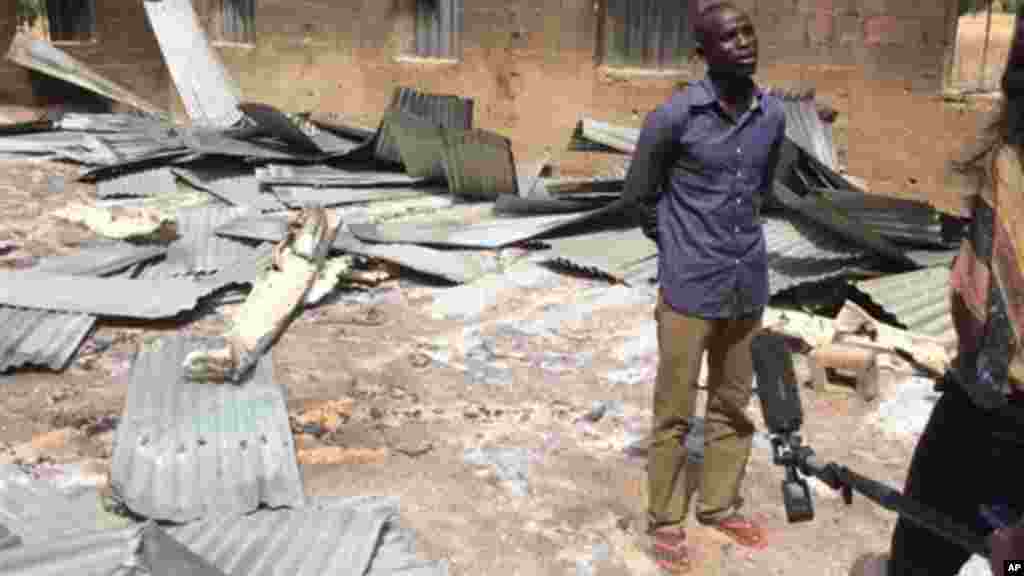 Bitrus Samuel, who claims he was in the Church when gunmen attacked speaks to a journalist inside the burned church, in Wada Chakawa, Yola, Nigeria.
