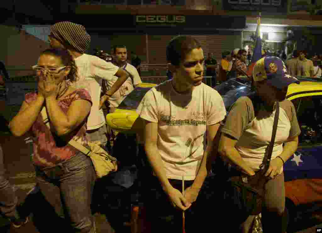 Opposition supporters react as they hear the official presidential elections results in Caracas, April 15, 2013. 