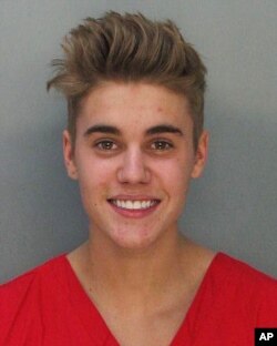 This police booking mug made available by the Miami Dade County Corrections Department shows pop star Justin Bieber, Jan. 23, 2014.