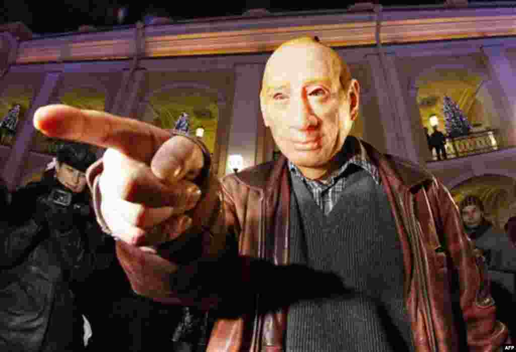 A protester wearing a mock mask depicting Russian Prime Minister Vladimir Putin gestures during a rally in downtown St.Petersburg, Russia, Thursday, Dec. 8, 2011. More than five hundreds people have protested in St.Petersburg against Prime Minister Vladim
