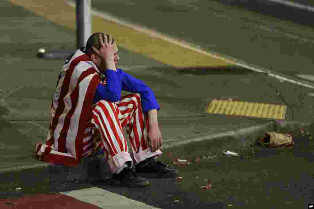 A man dressed in red-white-and-blue sits on the curb during a protest against President-elect Donald Trump, in Seattle&#39;s Capitol Hill neighborhood, Washington.