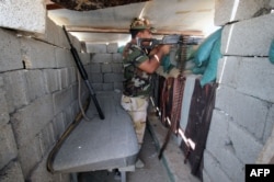 A member of the allied Iraqi forces, which consists of the Iraqi army and fighters from the Popular Mobilization units, guards a lookout point during clashes with Islamic State fighters on the outskirts of Fallujah, in Iraq's Anbar province, Aug. 13, 2015