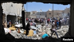 Men search for survivors amid debris of collapsed buildings after what activists said was an air raid by forces loyal to Syria's President Bashar al-Assad in Raqqa province, eastern Syria, August 10, 2013. 