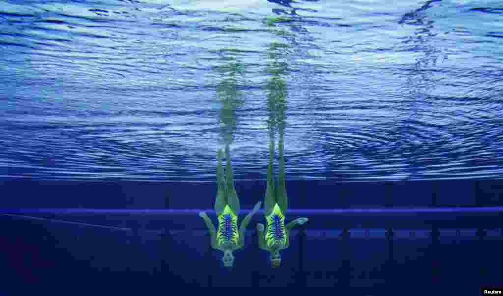 Italy's Giulia Lapi and Mariangela Perrupato perform underwater in the synchronised swimming duets technical routine qualification round.