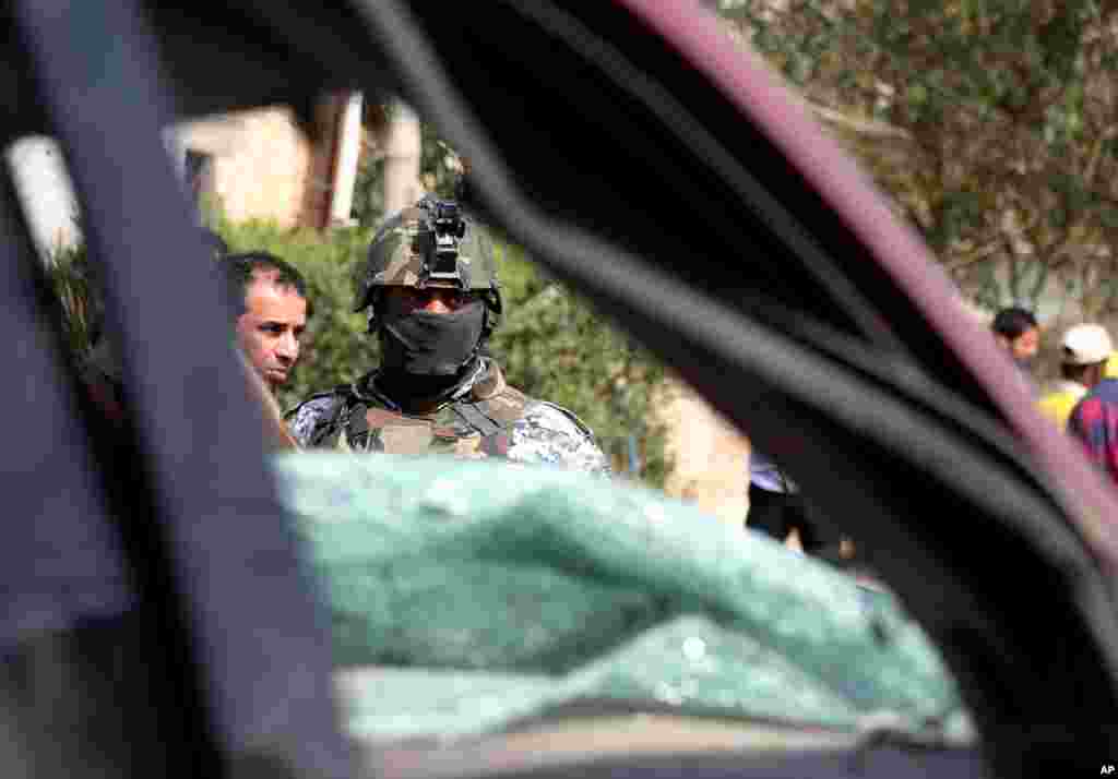 A police officer stands guard at the site of a car bomb attack in Baghdad, March 5, 2014.