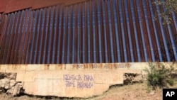 En esta foto del 4 de diciembre de 2017, un eslogan que pide justicia para el joven mexicano de 16 años José Antonio Elena Rodríguez, quien fue asesinado a tiros en una calle de Nogales, Sonora, México, se muestra en el muro fronterizo de las calles. donde fue asesinado.