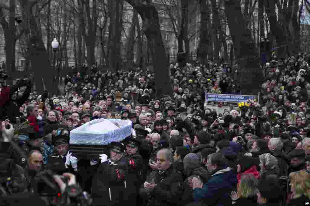 Mourners applaud as workers carry the coffin of Boris Nemtsov during a farewell ceremony at the Sakharov center in Moscow, Russia, March 3, 2015. 