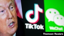 FILE PHOTO: A picture of U.S. President Donald Trump is seen on a smartphone in front of displayed Tik Tok and WeChat logos in this illustration