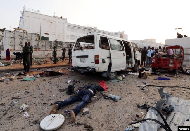 The dead body of an unidentified man is seen at the scene of an explosion in Mogadishu, Somalia, Nov. 9, 2018.
